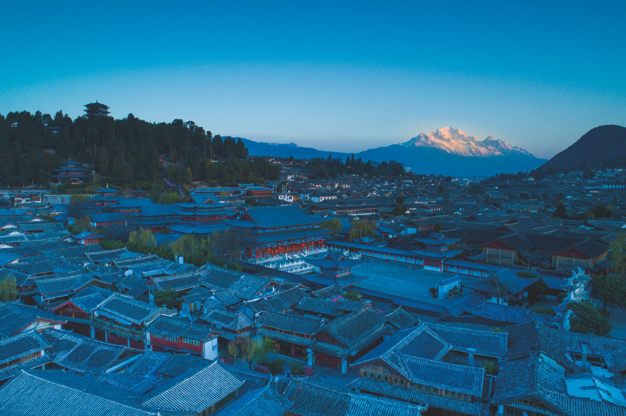 麗江古城與遠方玉龍雪山暮色